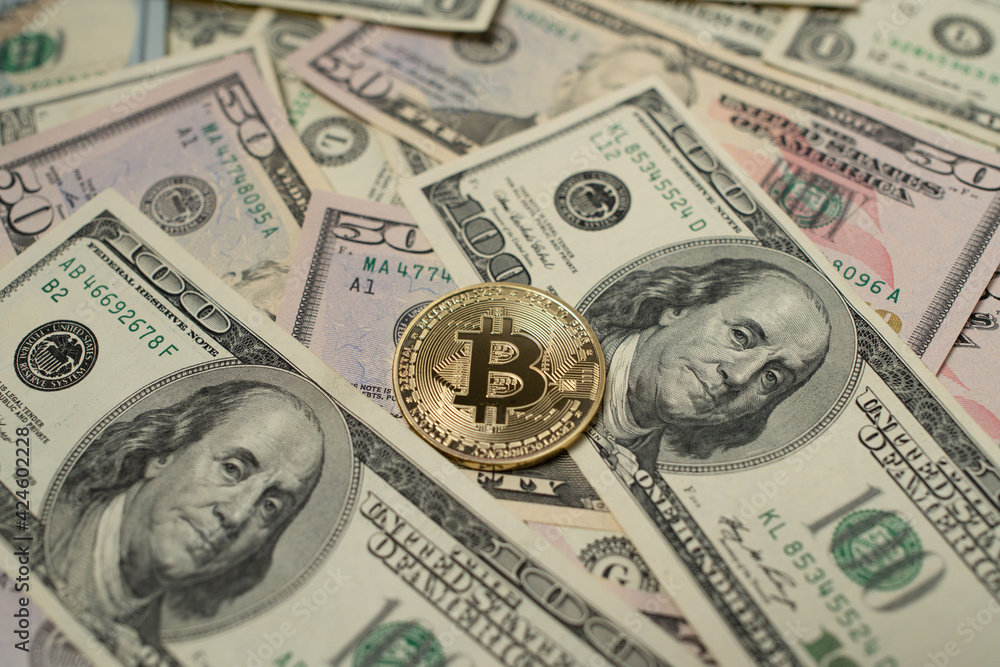Golden Bitcoin on top of Dollar Banknotes. Digital Crypto currency and fiat Money. US Dollar Cash. USD Background and BTC coin in center Golden Bitcoin on top of Dollar Banknotes. Digital Crypto currency and fiat Money. US Dollar Cash. USD Background and BTC coin in center