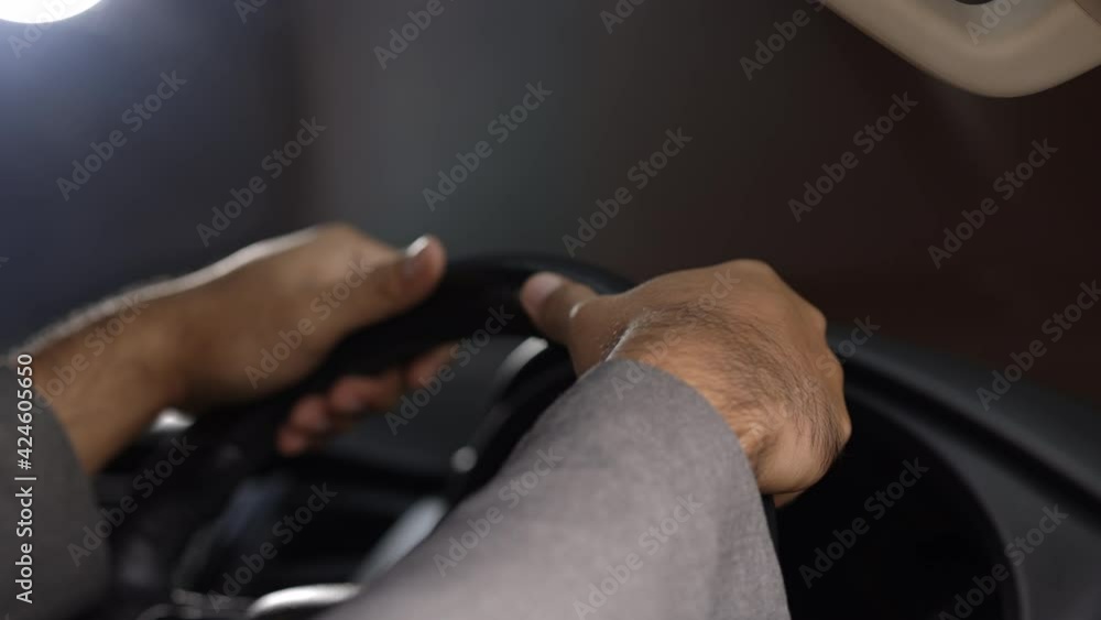 The businessman in suit his hand is holding the steering wheel of the car Safe driving. Young man getting new car he so happy and excited touching the steering wheel ready to drive the car. The businessman in suit his hand is holding the steering wheel of the car Safe driving. Young man getting new car he so happy and excited touching the steering wheel ready to drive the car.