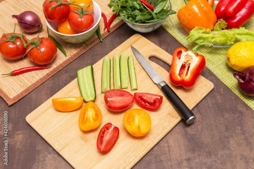Different vegetables for cooking healthy vegetarian vegan diet food. Cutting ingredients for salad on wooden board on kitchen