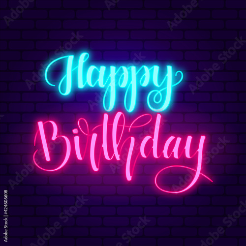 Happy birthday. Glowing pink and blue neon incription on dark brick wall background.