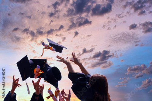 International students in mortar boards and bachelor gowns with diplomas. photo