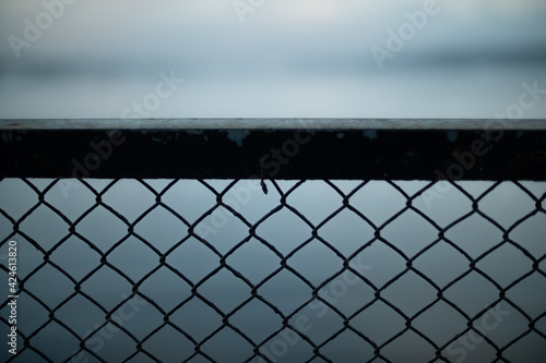 Chainlink fence against water and sky