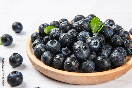Fresh blueberry with drops of water on wood background