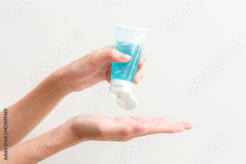 Hands of woman applying an antibacterial antiseptic hand gel.