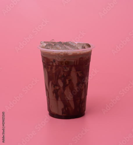 Plastic cup of iced cocoa on pink background