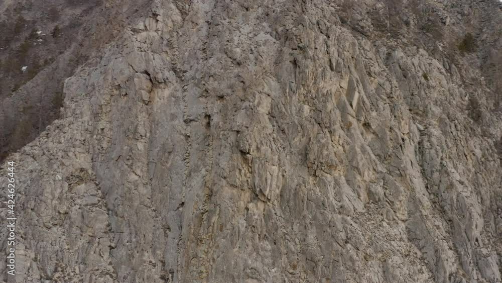 Flies around the rocky top of the mountain in a drone. Aerial footage Top of the mountain with growing trees. Flies around the rocky top of the mountain in a drone. Aerial footage Top of the mountain with growing trees.