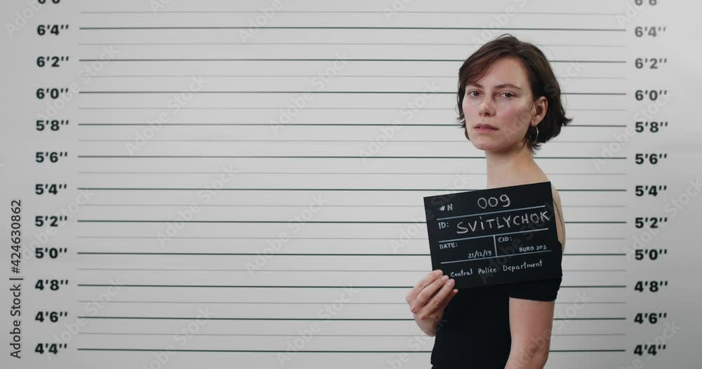 Mugshot of criminal young woman with short haircut turning head and ...