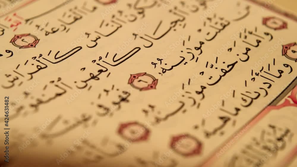 Detail of Page Turning of written pages of the Quran - Closeup slide shot Detail of Page Turning of written pages of the Quran - Closeup slide shot