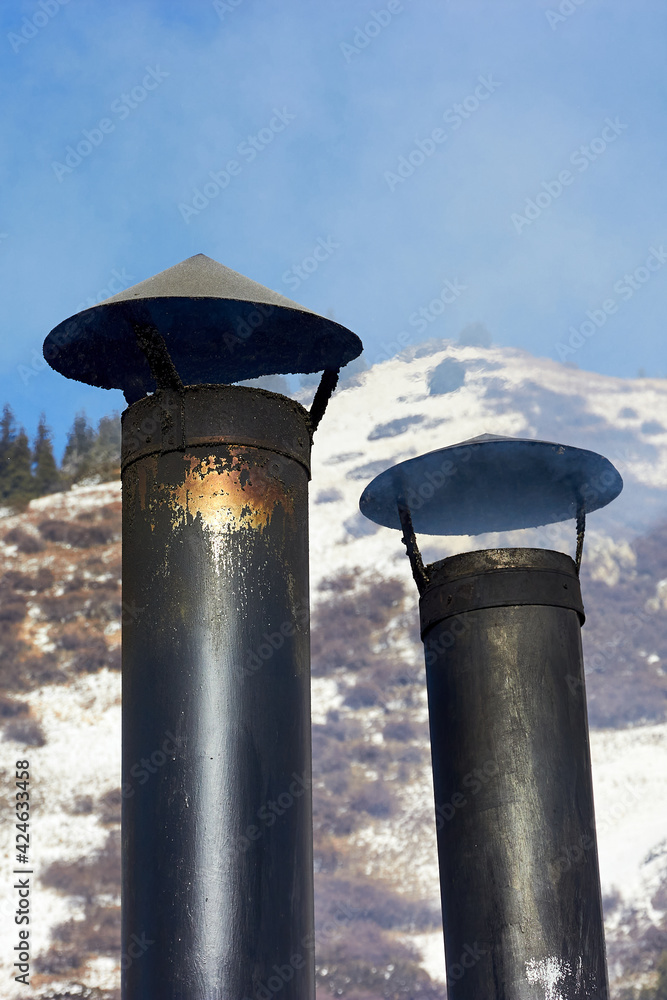 metal rooftop chimney of a diner against the backdrop of mountains and sky metal rooftop chimney of a diner against the backdrop of mountains and sky