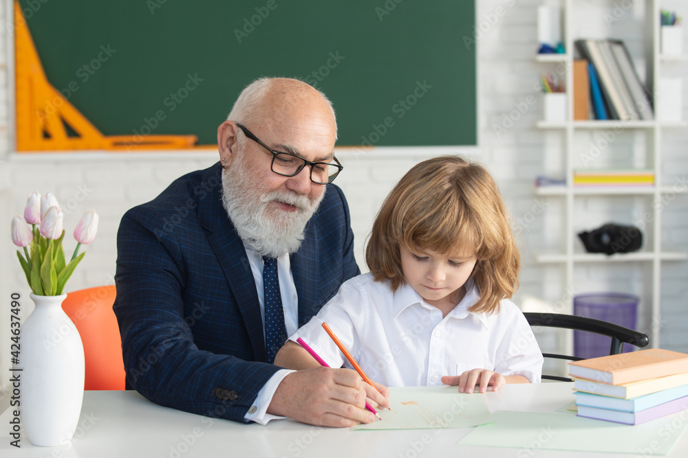 Happy kid in school. Teacher help to learn. Education, teachering, elementary school Happy kid in school. Teacher help to learn. Education, teachering, elementary school
