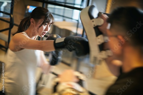 パーソナルトレーナーにキックボクシングを習うアジア人女性