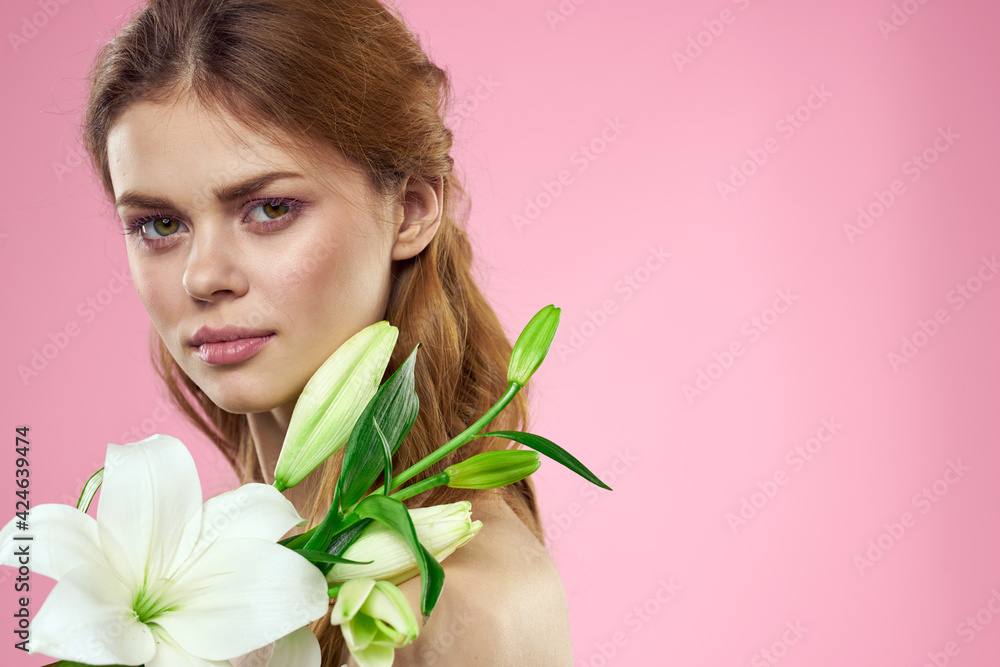 Portrait of a beautiful woman with white flowers in her hands on a pink background Copy Space cropped view Portrait of a beautiful woman with white flowers in her hands on a pink background Copy Space cropped view