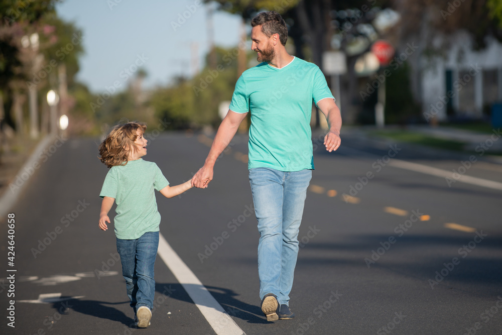 Father and son holding hands spending time outdoor together. Urban city walk family. Father and son holding hands spending time outdoor together. Urban city walk family.