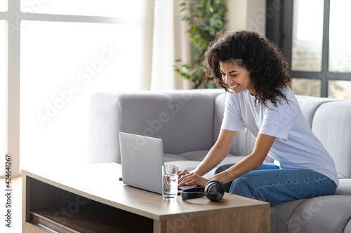 Young African American girl look at laptop screen talk speak on video call online. Technology concept