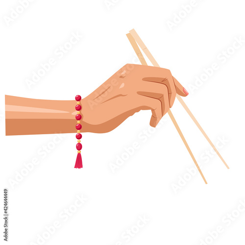 Image of a hand with Chinese chopsticks and a bracelet decoration