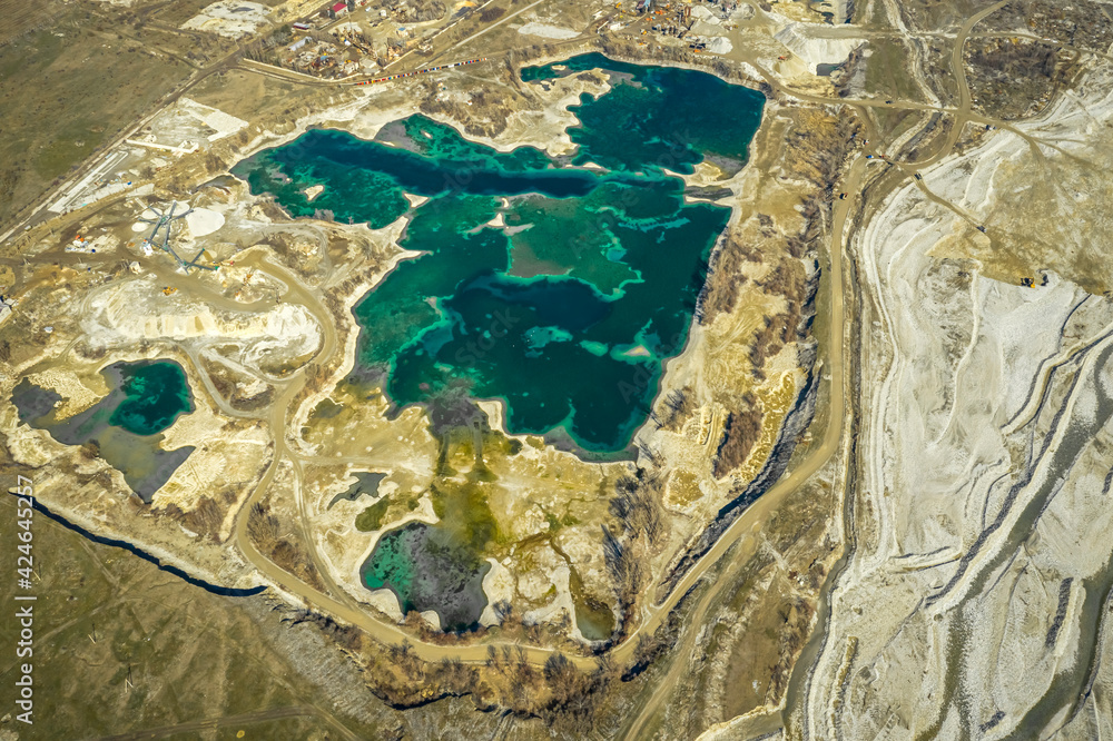 Industrial development of a sand pit. The quarry is filled with turquoise water. North Caucasus, Kabardino-Balkaria, Russia.