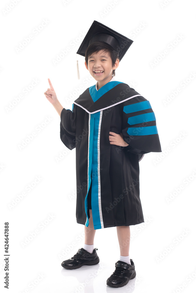 Asian boy student wearing graduation gown pointing finger to something on white background isolated Asian boy student wearing graduation gown pointing finger to something on white background isolated