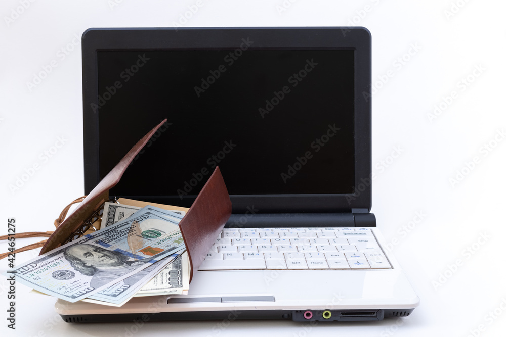 Laptop with blank black screen, open wallet with US dollars on a white background. Internet business concept. Laptop with blank black screen, open wallet with US dollars on a white background. Internet business concept.