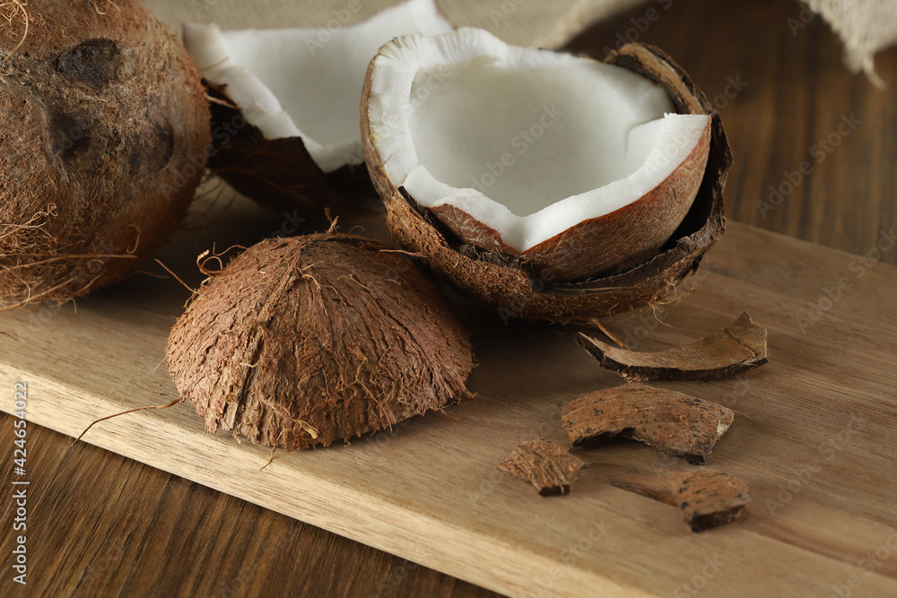 Half ripe coconut cut on a wooden background. Ripe coconut cut in half on a wooden background Half ripe coconut cut on a wooden background. Ripe coconut cut in half on a wooden background