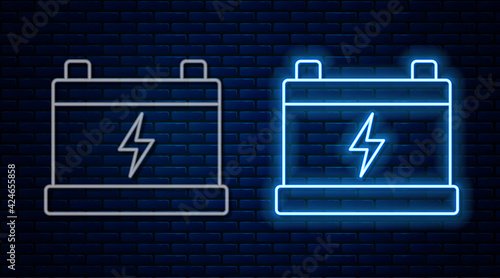 Glowing neon line Car battery icon isolated on brick wall background. Accumulator battery energy power and electricity accumulator battery. Vector