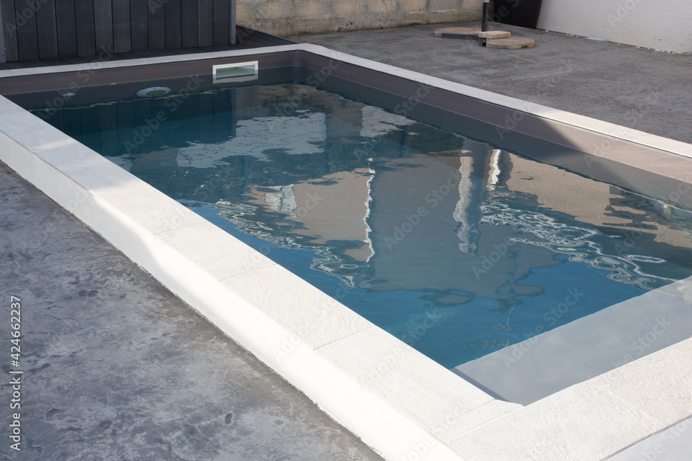 contemporary cement swimming pool with staircase and modern border with blue water