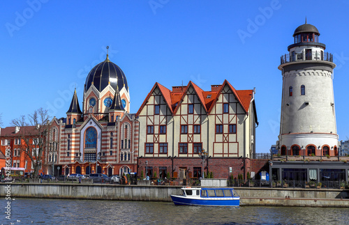 Synagogue in Kaliningrad on the banks of the Pregol River and a lighthouse in the Fishing village photo
