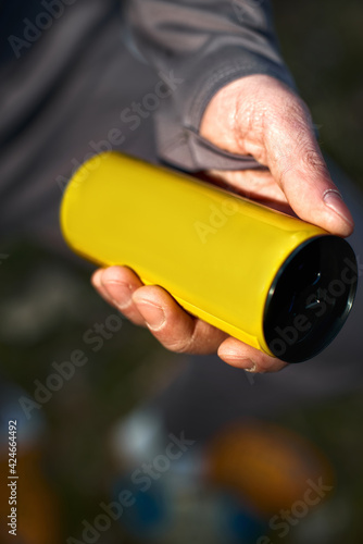 guy holding aluminum can Yellow with beverage, closeup. Mockup for design