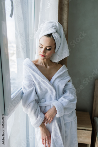 Beautiful young healthy woman relaxing in a robe, hotes, room, spa salon