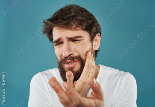 Man gesturing with his hands on a blue background closeup portrait of emotion
