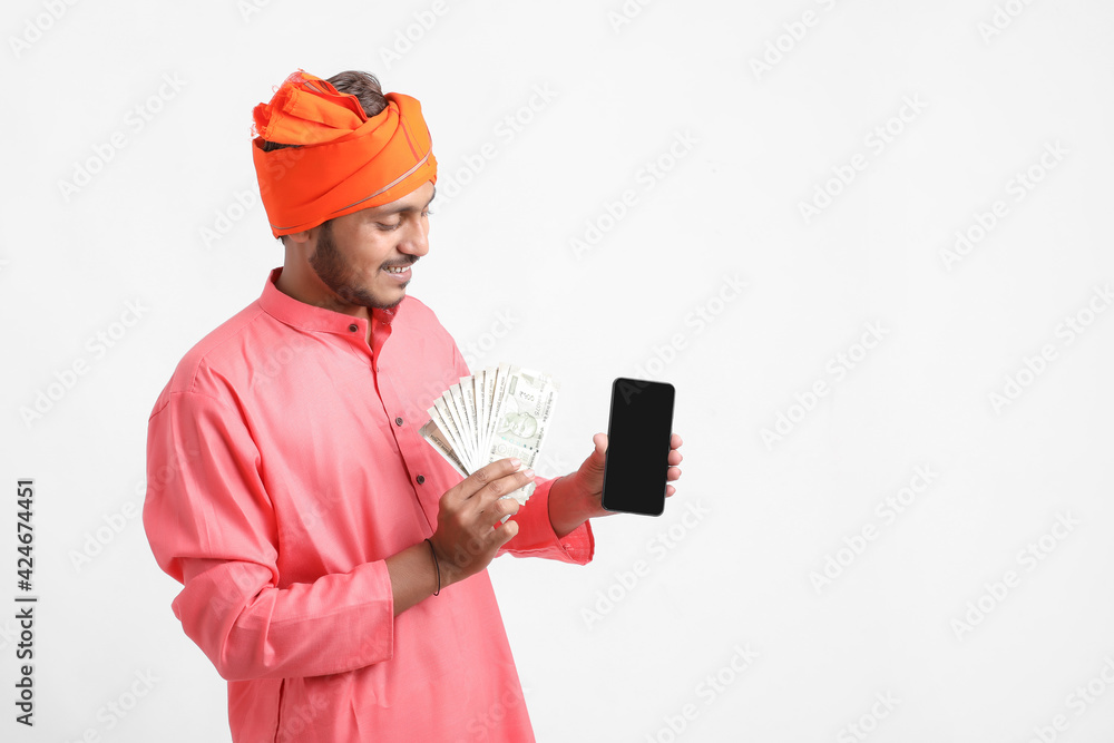 Young indian farmer using smartphone and showing money on white background. Young indian farmer using smartphone and showing money on white background.