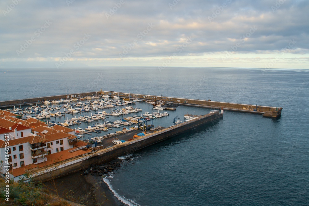 Puerto de la ciudad Santiago del Teide, localidad de la costa sur de la isla de Tenerife, Islas Canarias, España. Barcos atracados al resguardo de las inclemencias marinas del océano Atlántico.