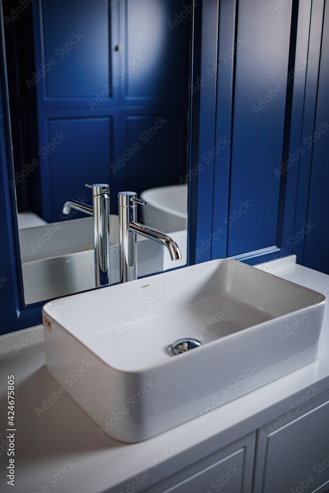 white bathroom sink on blue wall background white bathroom sink on blue wall background