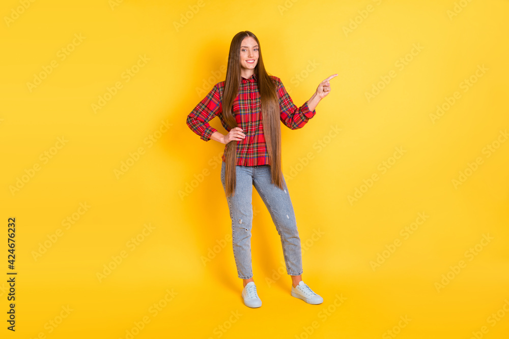 Full size photo of young happy smiling lovely beautiful girl advertising product isolated on yellow color background Full size photo of young happy smiling lovely beautiful girl advertising product isolated on yellow color background