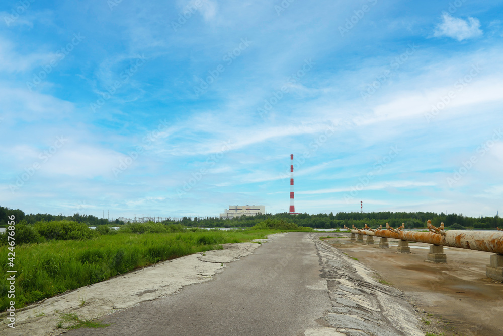 View of the rusty industrial water cooling installations against the background of the power plant.