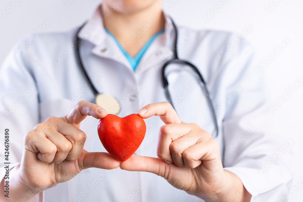 Doctor holding red heart shape in hand Doctor holding red heart shape in hand