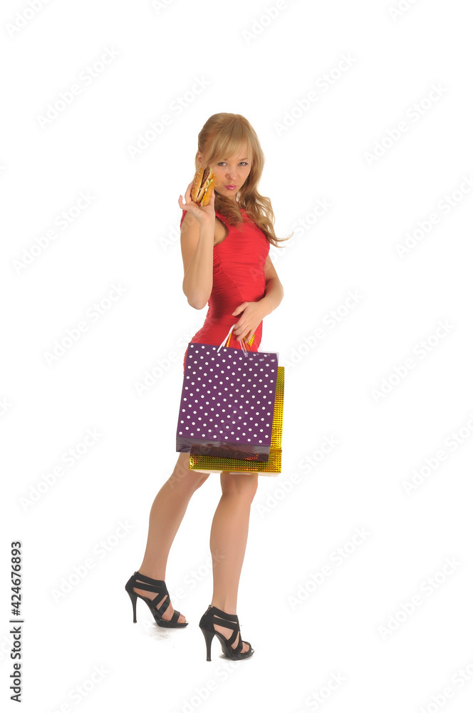 Young beautiful woman with some shopping bags and hamburger isolated on white Young beautiful woman with some shopping bags and hamburger isolated on white