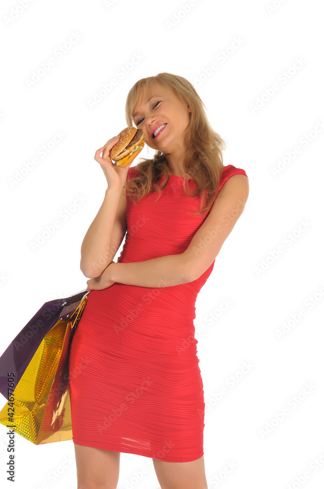 Young beautiful woman with some shopping bags and hamburger isolated on white