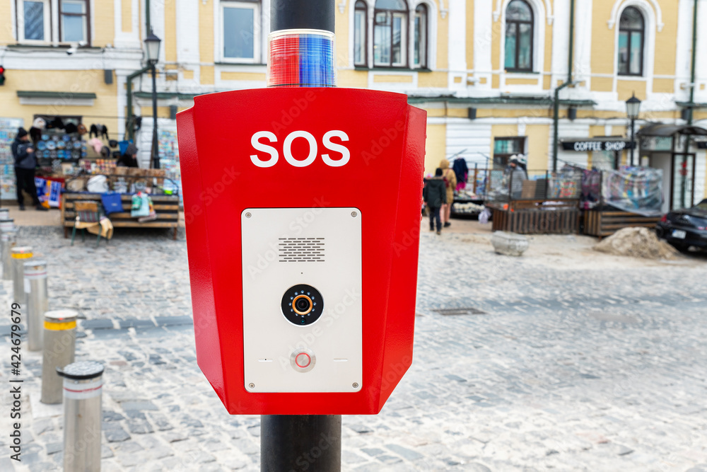 Red emergency police SOS call button alarm box with light bar, cctv camera and speaker device for urgent comunication on city street. Modern smart communication technology public space. Civil safety Red emergency police SOS call button alarm box with light bar, cctv camera and speaker device for urgent comunication on city street. Modern smart communication technology public space. Civil safety
