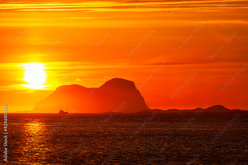 View at a rocky coastline at sunset with a fishing boat