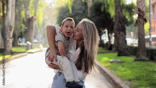Happy mom play with her son during they walking outdoors. Kid with physical diability. Video of enjoy happy love family outdoors. Happy moments. Disability care concept