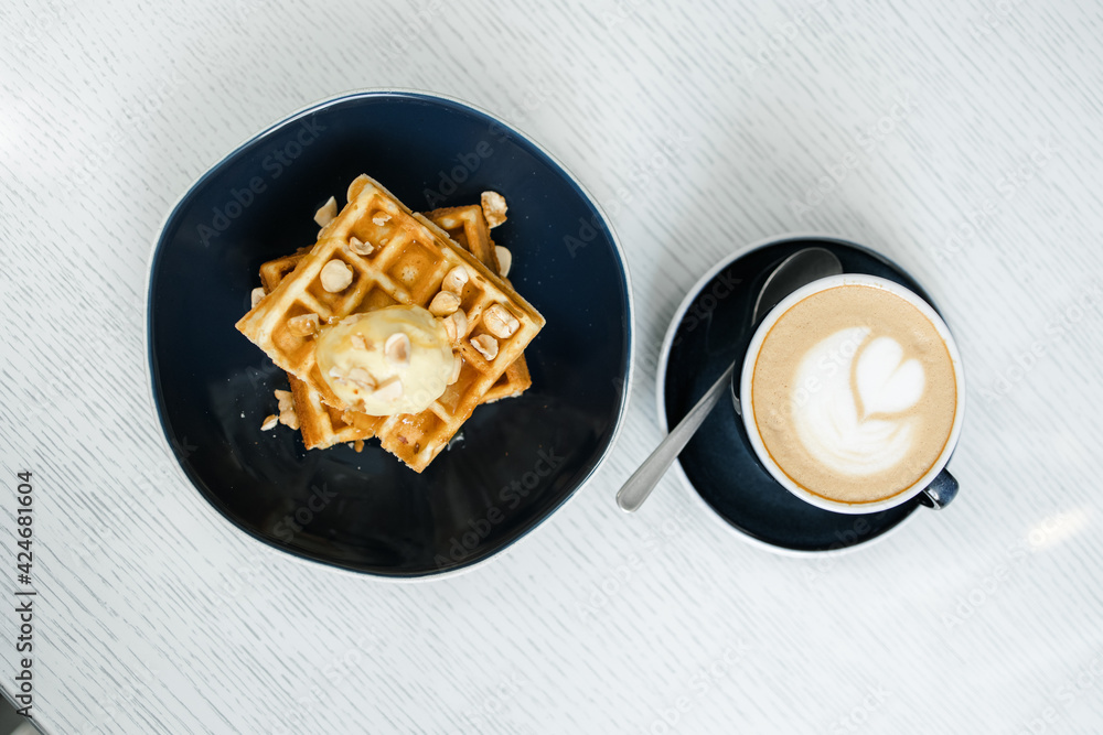 breakfast of Viennese waffles with mousse and cappuccino on the table at the hotel breakfast of Viennese waffles with mousse and cappuccino on the table at the hotel