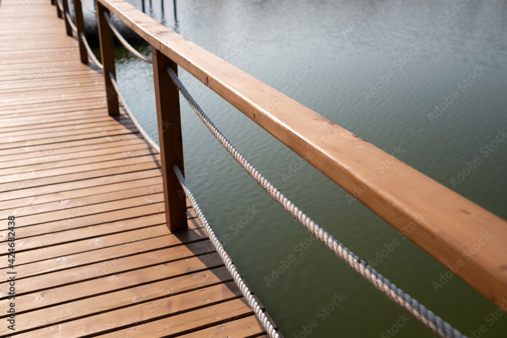 Fototapeta premium Closeup of a wooden bridge over the lake.