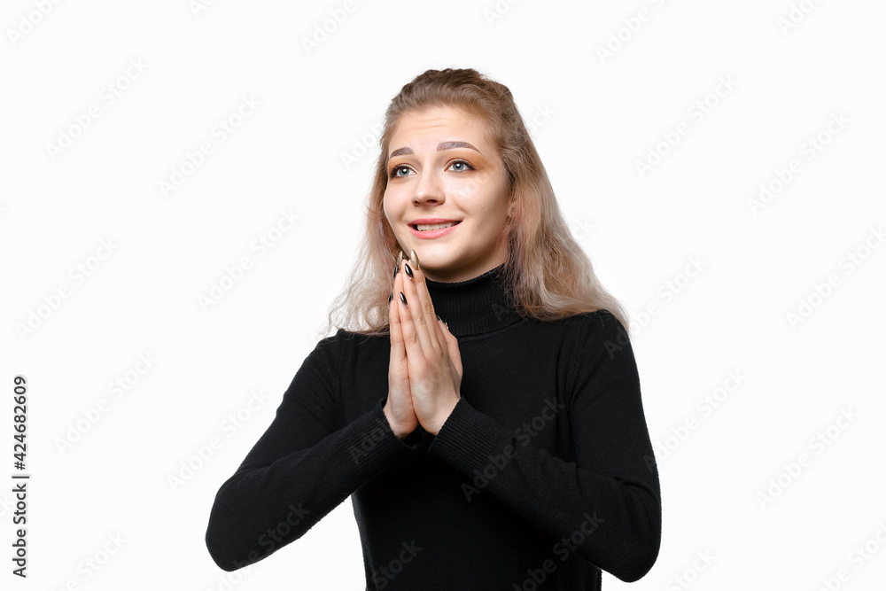 Young hopeful woman praying, looking aside pleading everything be okay, concerned for someone, white background Young hopeful woman praying, looking aside pleading everything be okay, concerned for someone, white background