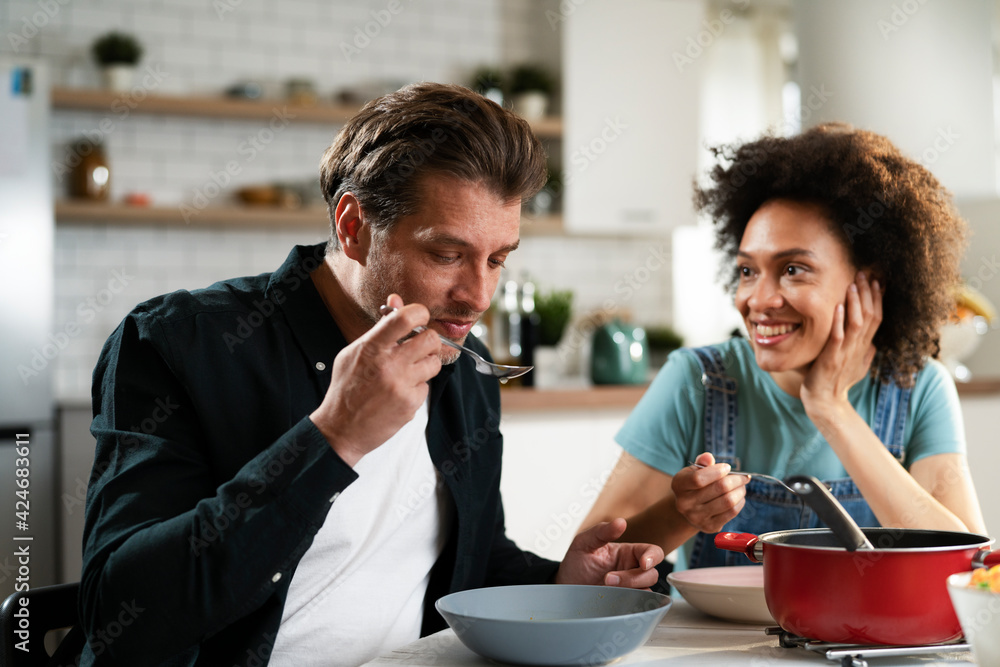 Boyfriend and girlfriend eating lunch together at home. Husband and wife enjoying in delicious food. Boyfriend and girlfriend eating lunch together at home. Husband and wife enjoying in delicious food.