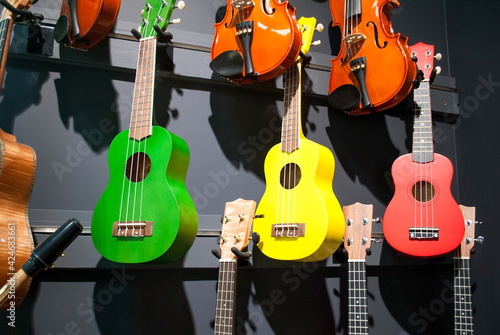 Colorful ukulele selling in music store. Small bright wooden guitar photo