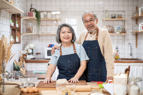 Portrait of Asian senior couple standing in the kitchen cooking bakery