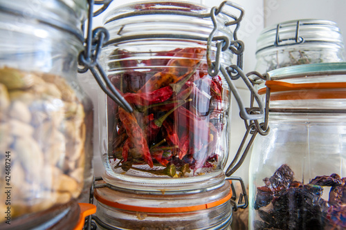 Condimentos en tarro de cristal, ajos, guindilla, pimiento seco. Condiments in glass jar, garlic, chilli pepper, dry pepper.