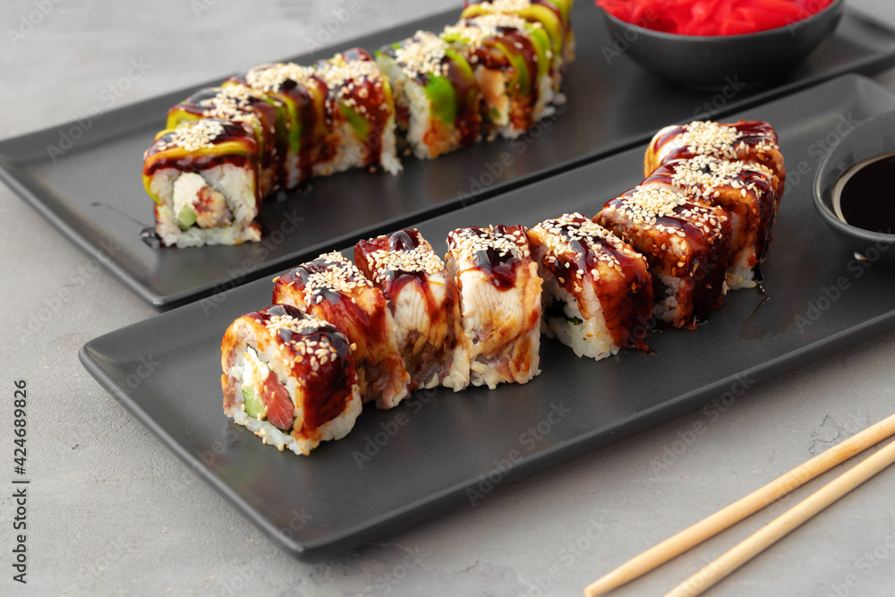 Dragon sushi rolls with eel and avocado on gray table Dragon sushi rolls with eel and avocado on gray table