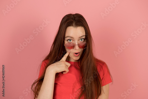 Girl in pink glasses on pink background