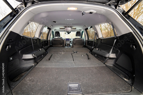 rear view open car trunk with folded passenger seats. large empty flat flor car trunk close up. huge suv trunk